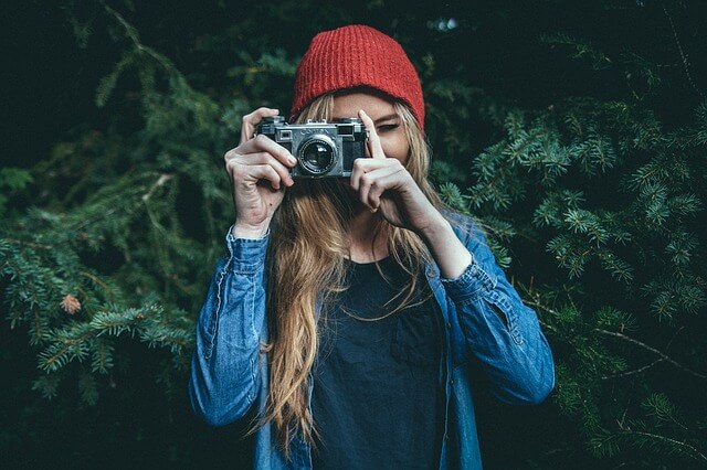 Dziewczyna hipster robiąca zdjęcia starym aparatem
