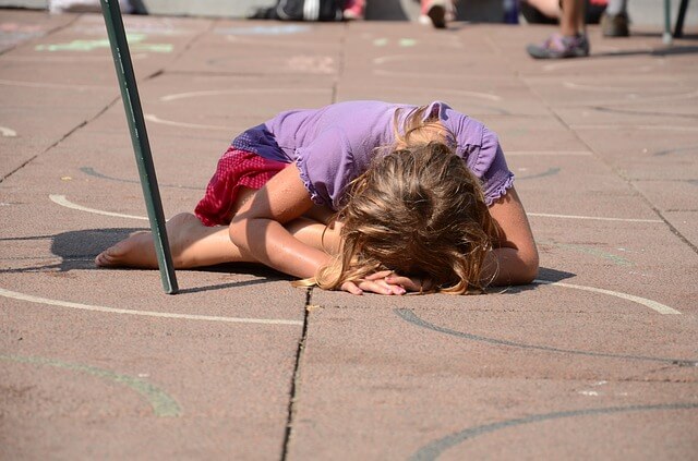 Mała dziewczynka leży na środku ulicy